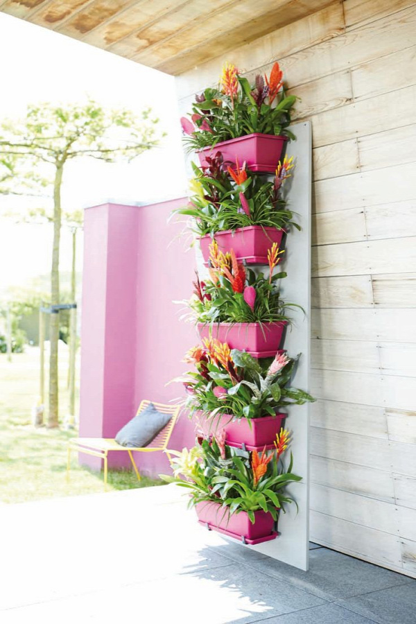 a nice way to brighten up your balcony - brightly painted flower pots placed vertically on a wall