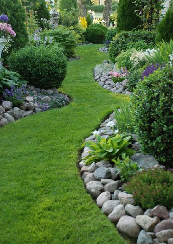 Stone border. Love the winding grass pathway. Not too much to mow. Soft meandering path by which to enjoy the garden.
