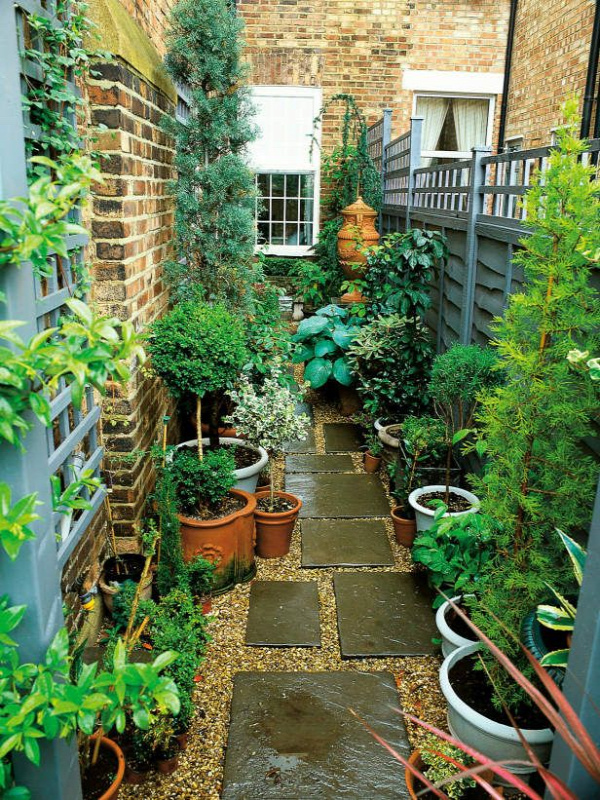 Narrow Garden Space of Townhouse This very narrow space on the side of a townhouse is made more interesting by using an interesting paving pattern with tiles and pea gravel, plus a variety of plants in pots.